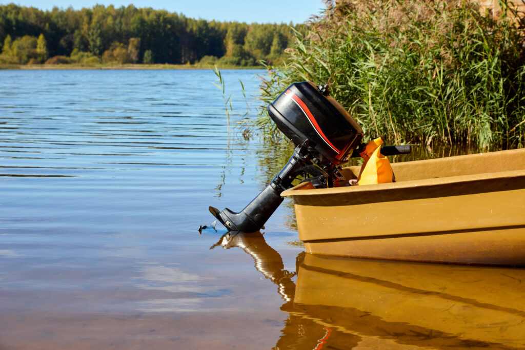 A serene lake view featuring a moored boat with an outboard motor, clear skies, and lush greenery. Perfect for nature and outdoor adventure themes
