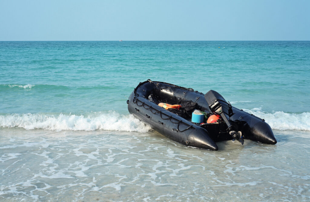 Black inflatable motor boat on the beach