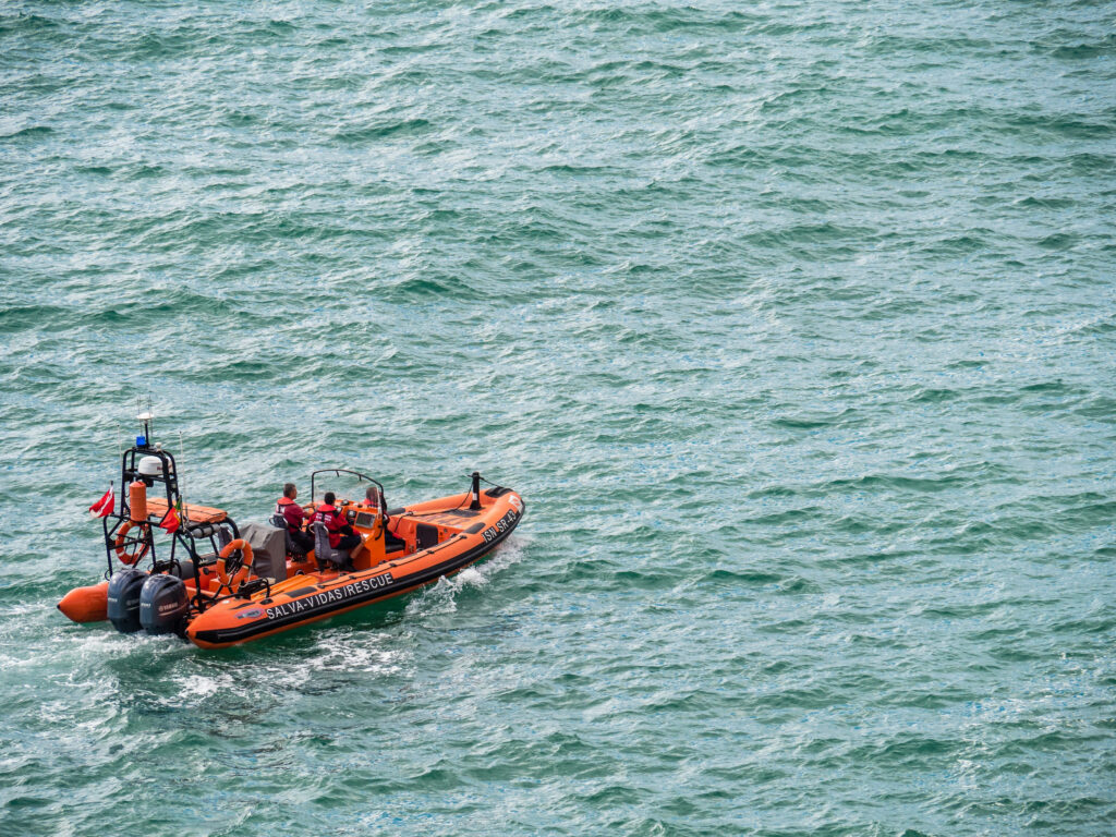 A rubber duck rigid inflatable boat sales out in the distance with 2 motors