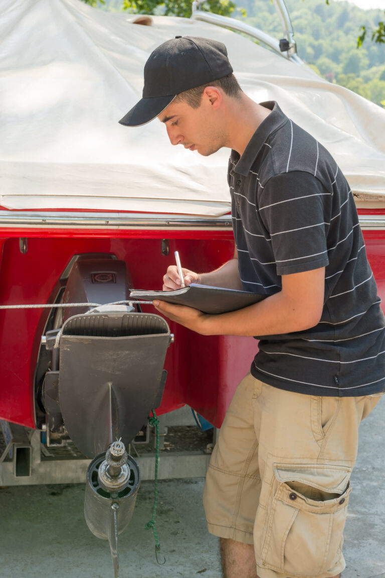 a young mechanic checking the motor boat for inspection